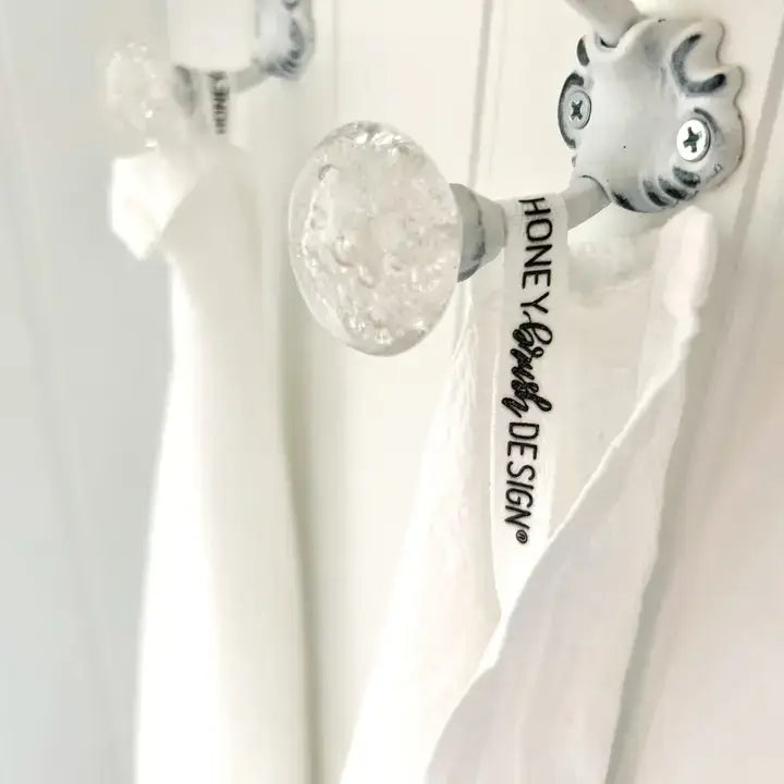 Decorative towel with festive design featuring pomegranates, oranges, and cinnamon sticks on a kitchen towel rack.
