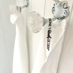 Decorative towel with festive design featuring pomegranates, oranges, and cinnamon sticks on a kitchen towel rack.