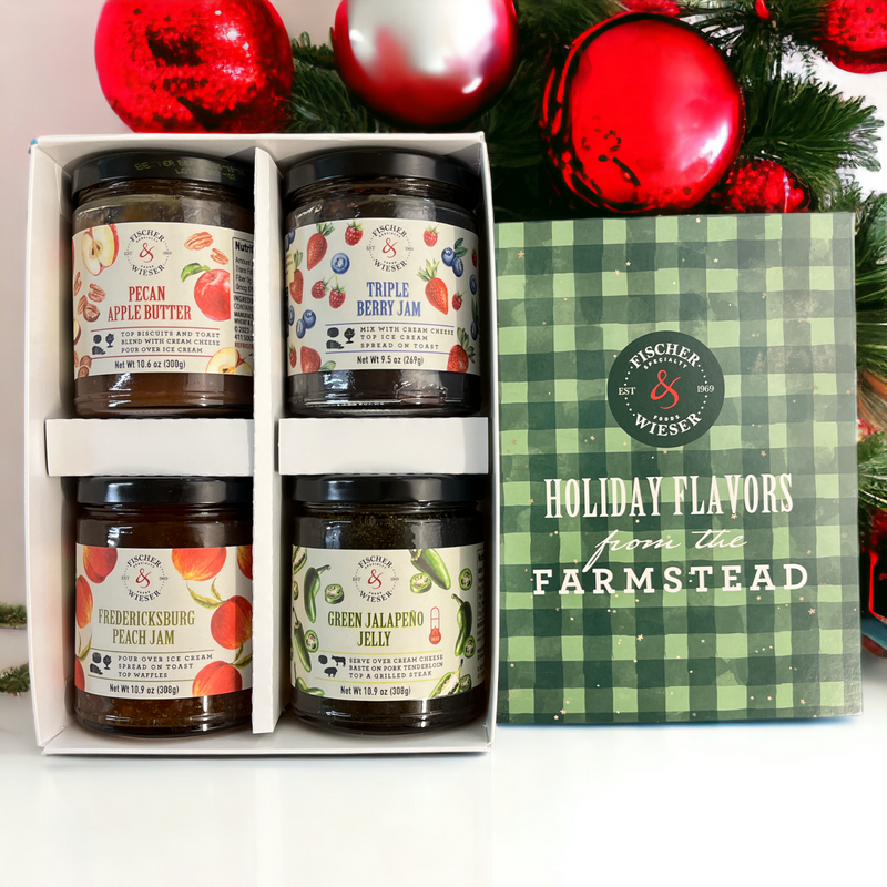 Set of jars with labels in a box, featuring 'Fischer & Wieser' brand, against a festive background.
